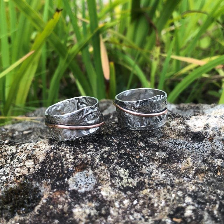 Textured-silver-copper-wrap-rings-on-rock