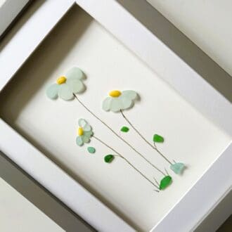 framed picture of three sea glass flowers made from the palest blue nuggets of Cornish sea glass