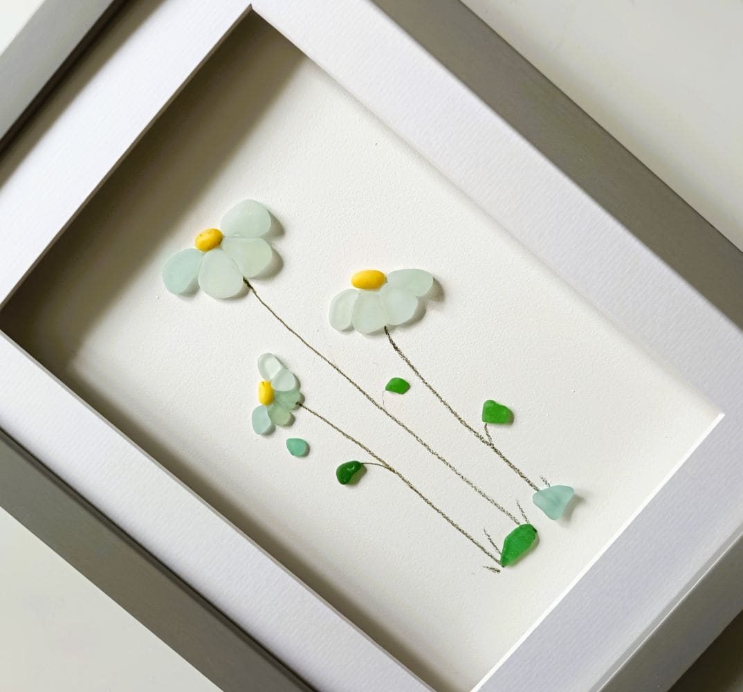 framed picture of three sea glass flowers made from the palest blue nuggets of Cornish sea glass