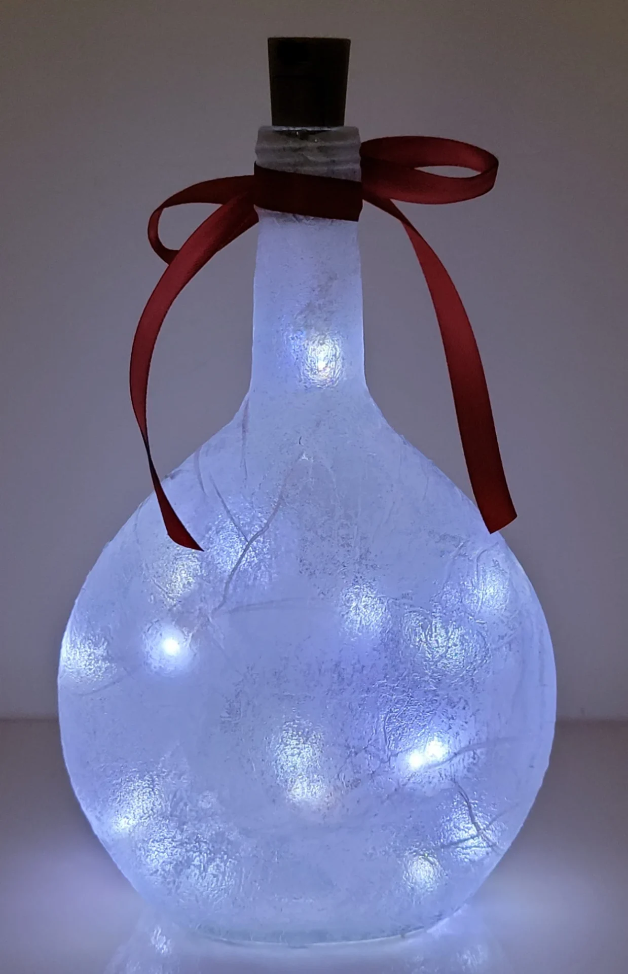 Lit up Round bottle with red ribbon and cork LED lights