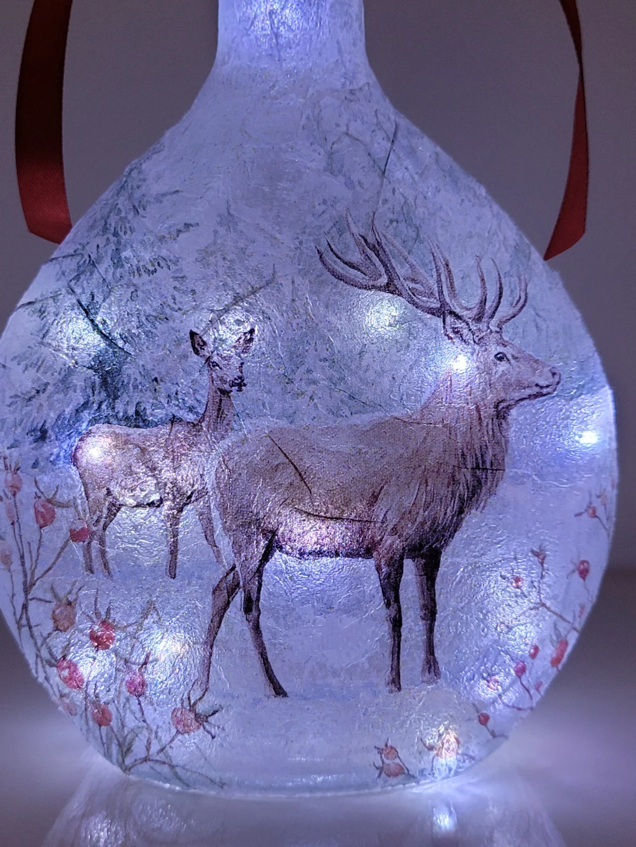 round bottle with stag detail lit up with cold white lights