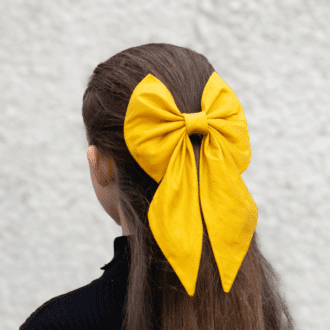 yellow silk hair bow worn on back of head over half updo