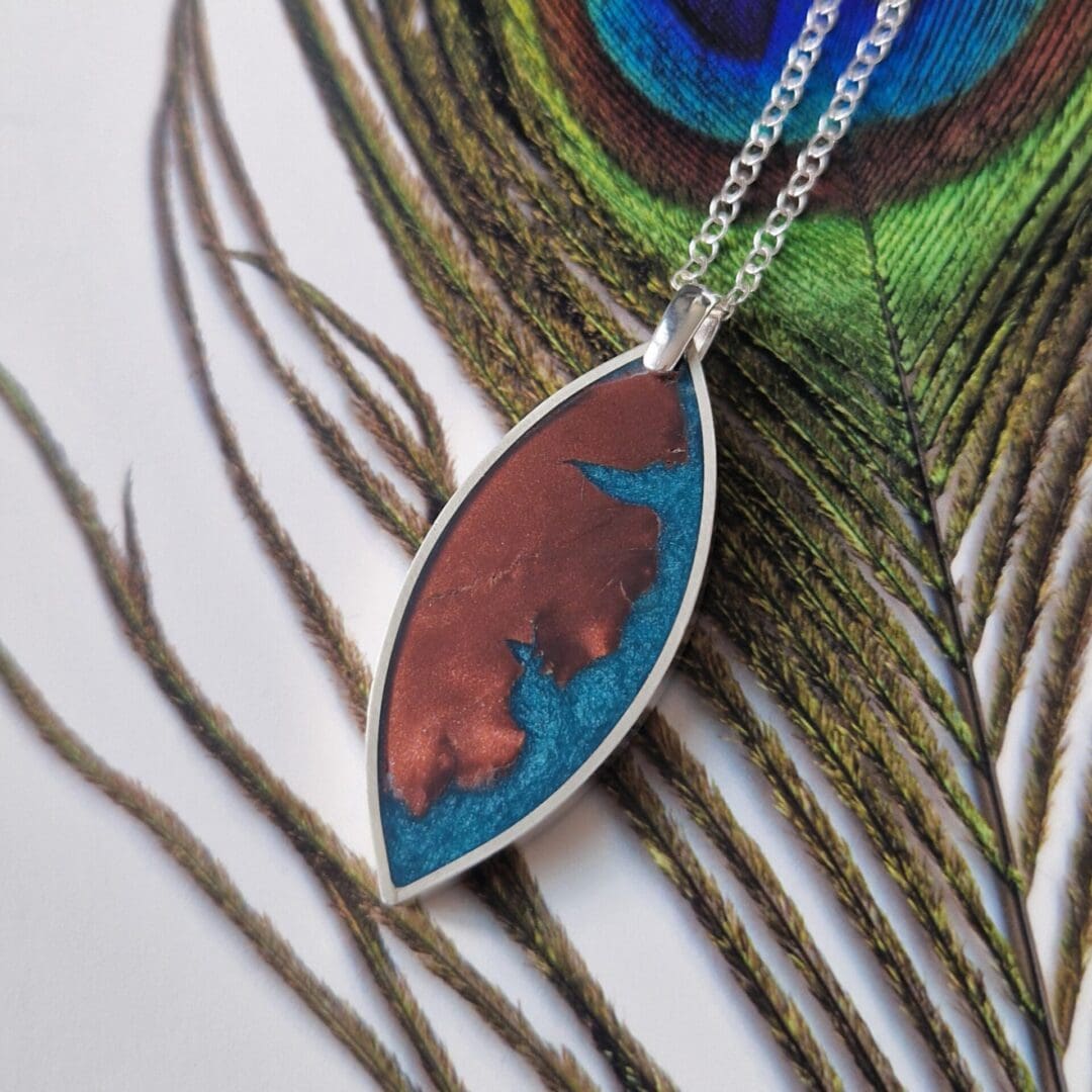 Handmade sterling silver leaf pendant, inlayed with teal resin and chestnut toned polymer clay.