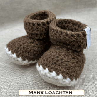 Pair of dark brown baby booties crocheted with a sheepskin sole in handspun Manx Loaghtan wool by Midge Porter Design