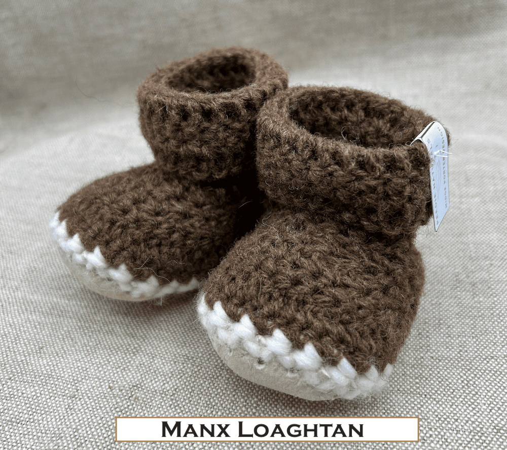 Pair of dark brown baby booties crocheted with a sheepskin sole in handspun Manx Loaghtan wool by Midge Porter Design