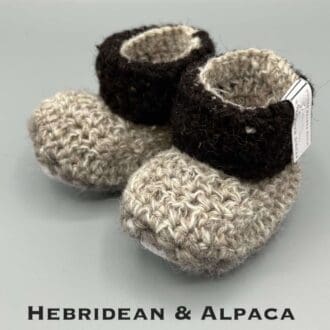 Pair of light brown lower and dark brown cuff upper baby booties crocheted with a sheepskin sole in Hebridean and Alpaca wool by Midge Porter Design