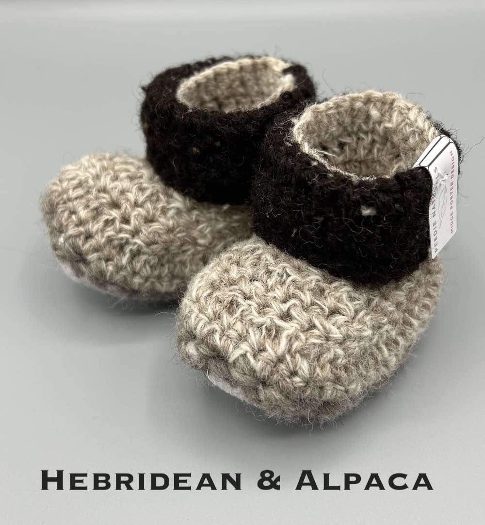 Pair of light brown lower and dark brown cuff upper baby booties crocheted with a sheepskin sole in Hebridean and Alpaca wool by Midge Porter Design