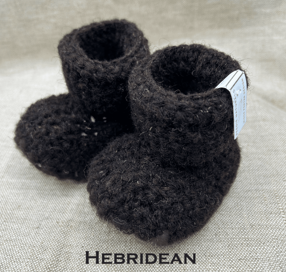 Pair of dark brown baby booties crocheted with a sheepskin sole in Hebridean wool by Midge Porter Design