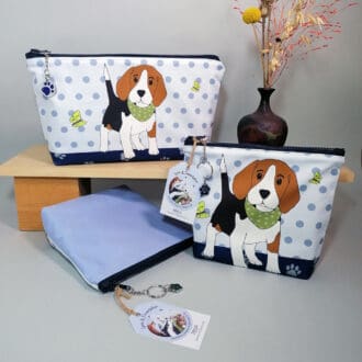 Large toiletries bag and make up bag featuring a cute beagle puppy wearing a bandana with his green butterfly friends. Water resistant lining, pocket. Chunky zipper fastening with sparkly paw print charm zip pull