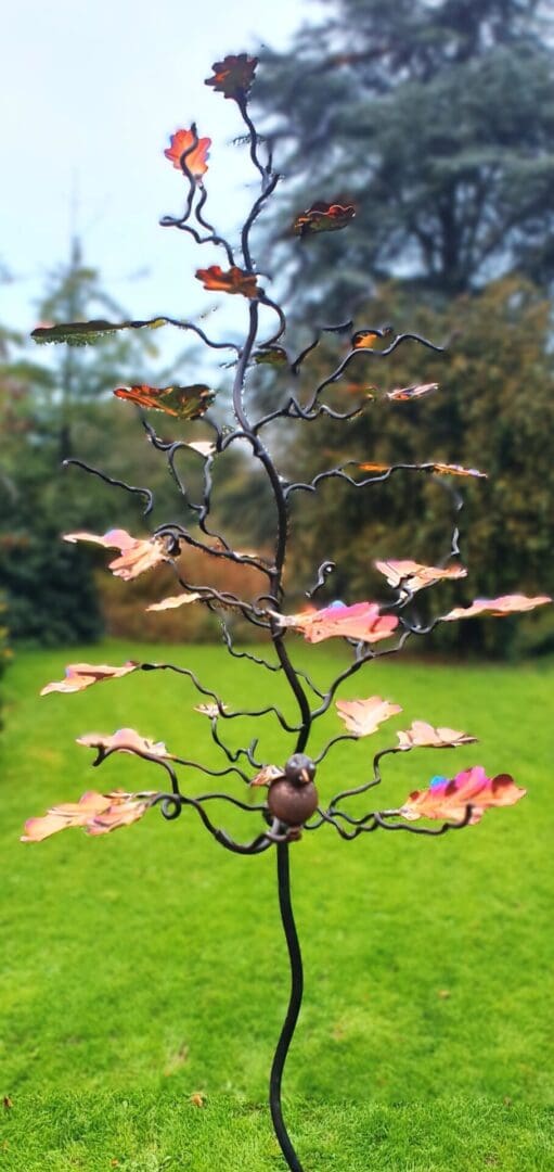 Our beautiful 15 leaf Oak tree bird feeder tree stand and sculpture in mild steel 15 marine grade stainless steel UV stable leaves in a myriad of colours from copper, gold pinks, purples and blues. Often ordered as a personalised family tree,