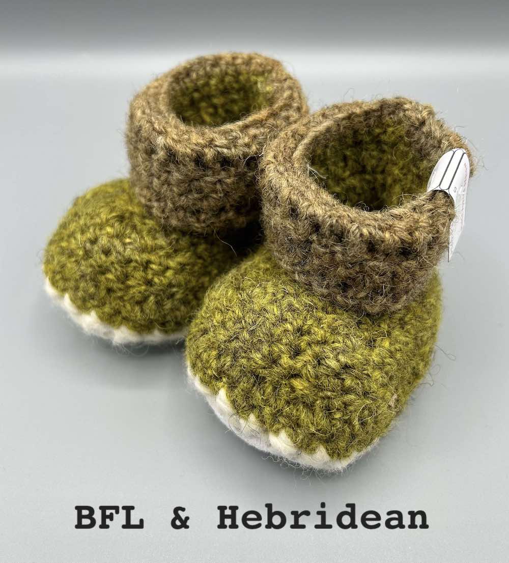 Pair of naturally dyed (using bog myrtle, nettle, moss and bark) two-tone green baby booties crocheted with a sheepskin sole in Hebridean and Blue Faced Leicester wool by Midge Porter Design