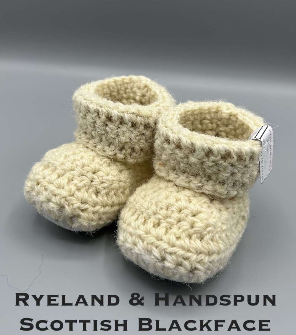 Pair of ecru baby booties crocheted with a sheepskin sole in handspun Scottish Blackface and Ryeland wool by Midge Porter Design