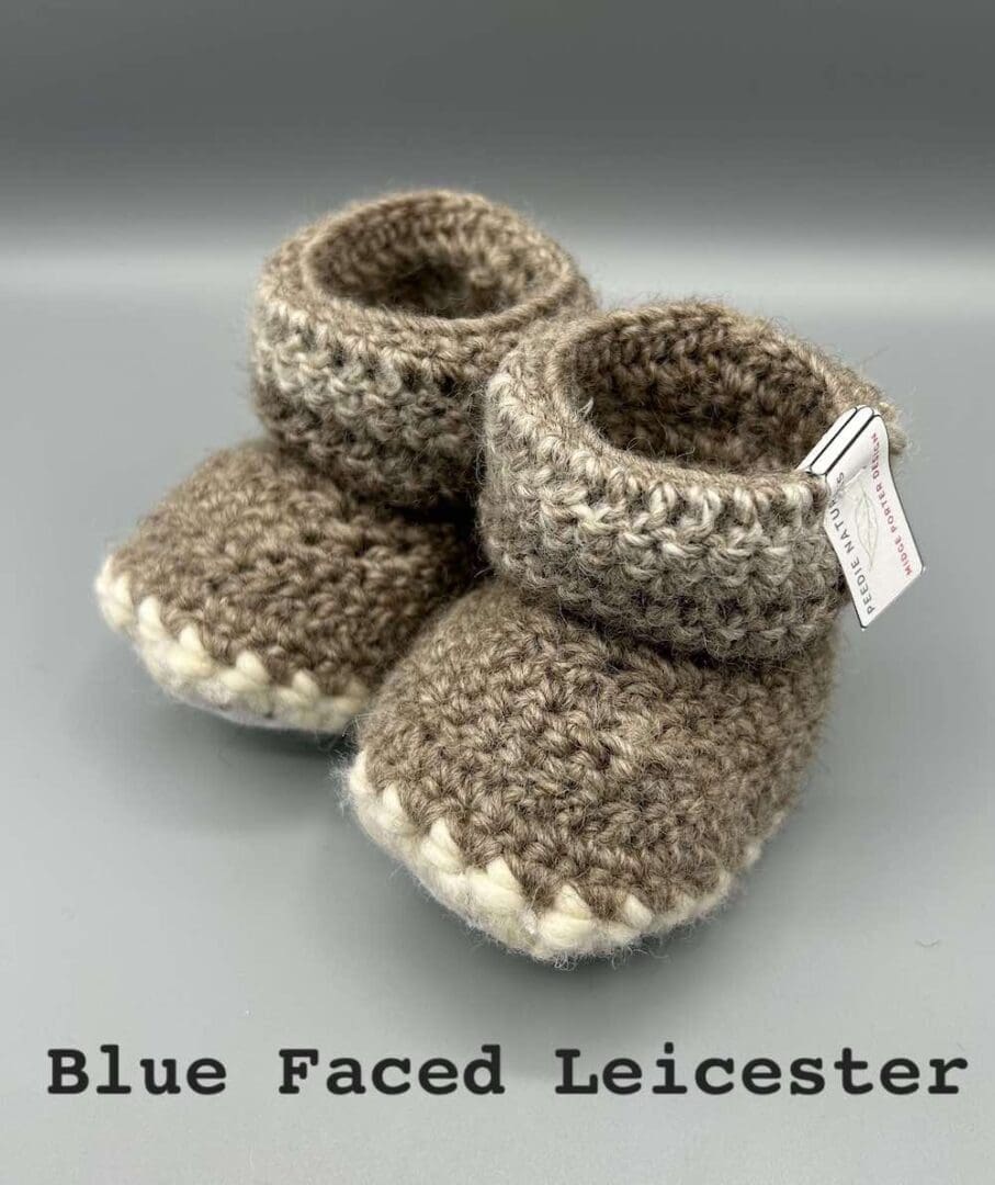 Pair of beige variegated baby booties crocheted with a sheepskin sole in Bluefaced Leicester and Bluefaced Kerry Hill wool by Midge Porter Design