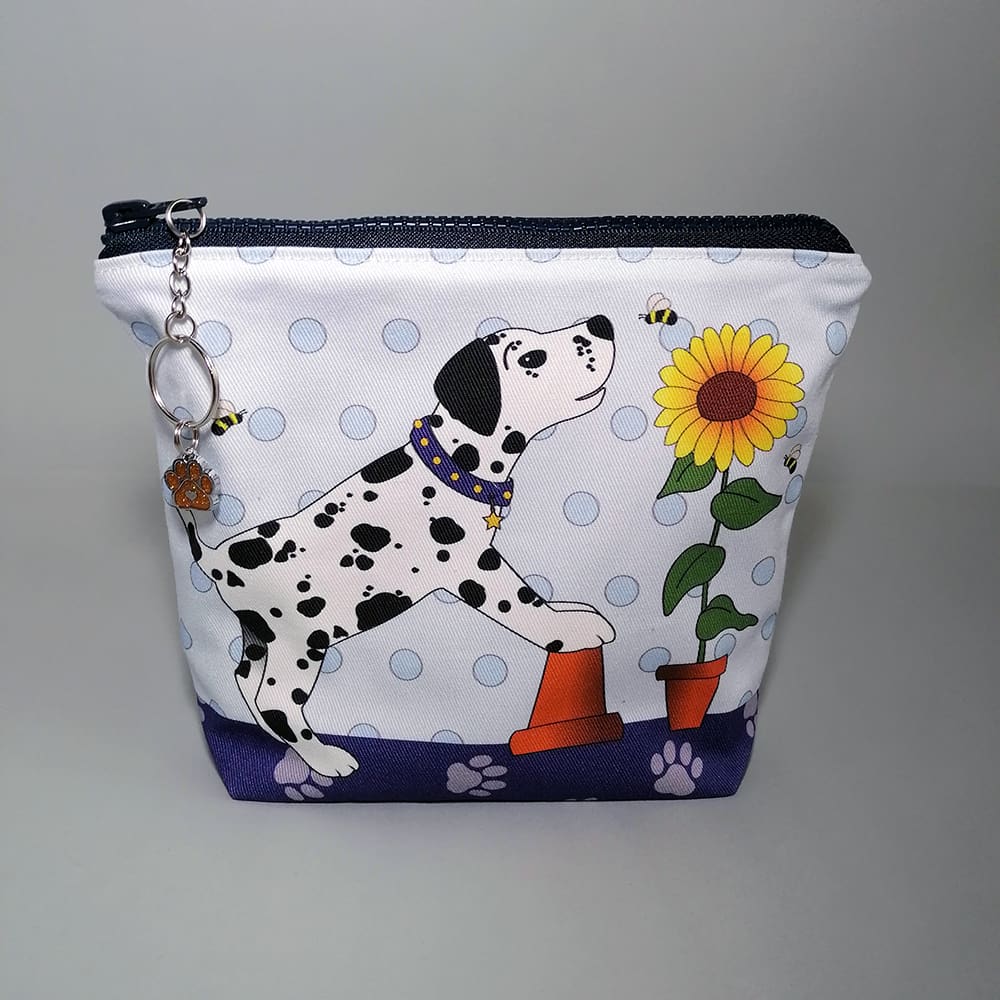 Spotty dog and sunflower print make up bag. Handmade in soft cotton with a water resistant lining and internal pocket. Sealed with a chunky zipper fastening with a ring and chain zip pull decorated with a dog paw charm.