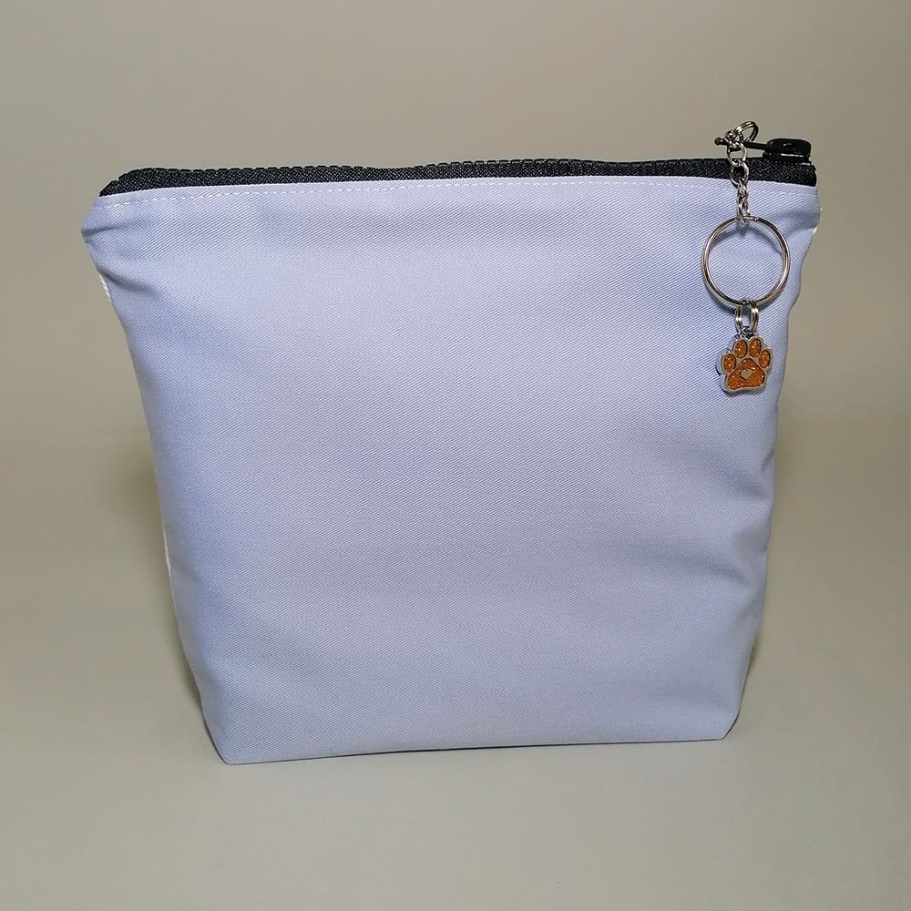 Pale blue cotton reverse of the spotty dog make up bag. Sealed with a chunky zipper and sparkly paw charm zip pull