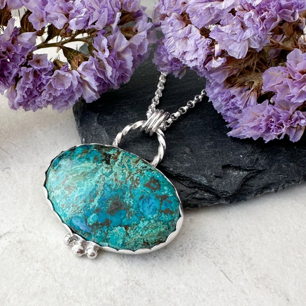 Teal green and blue shattuckite gemstone set in a handmade silver necklace