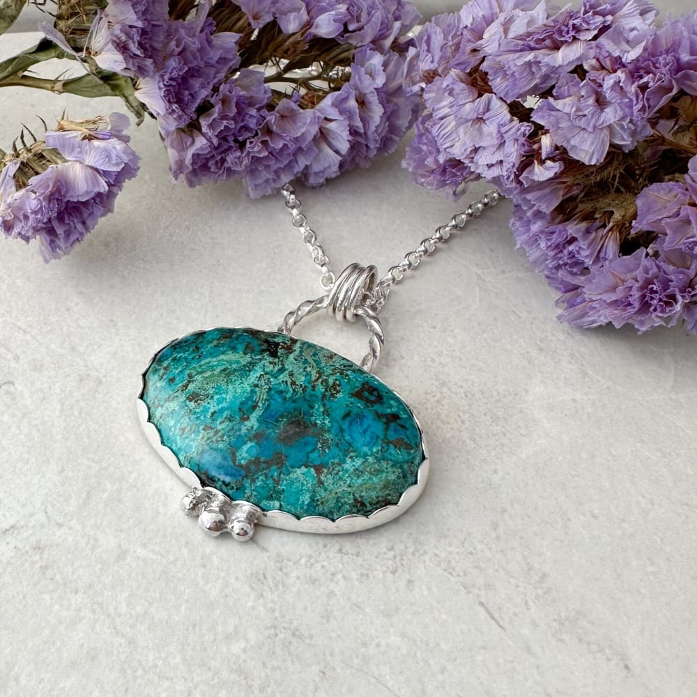 Blue and green shattuckite gemstone set in a handmade silver necklace