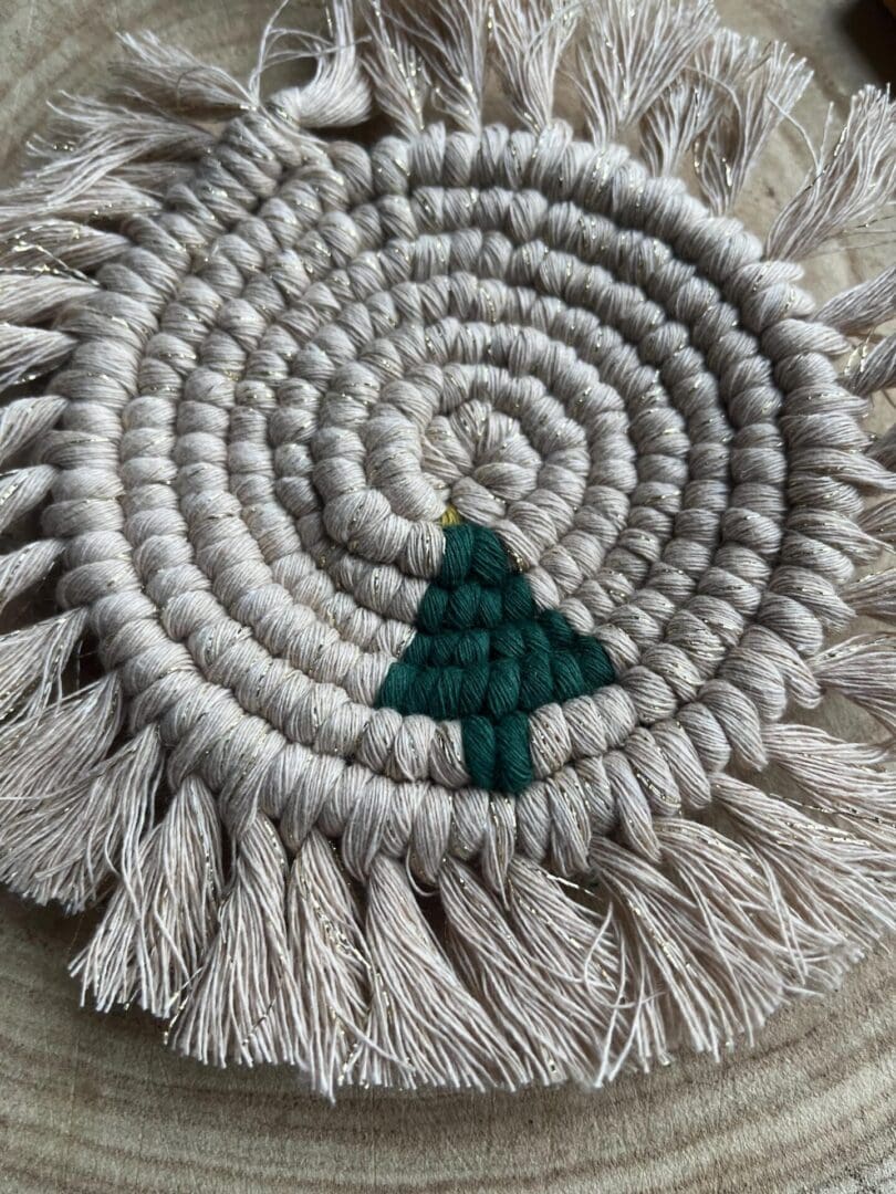 Handmade macrame coaster made with recycled cotton, with a Christmas tree design