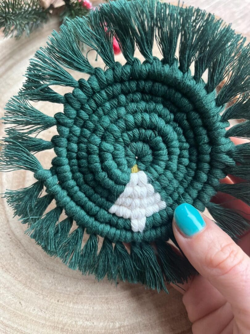 Handmade macrame coaster made with recycled cotton, with a Christmas tree design