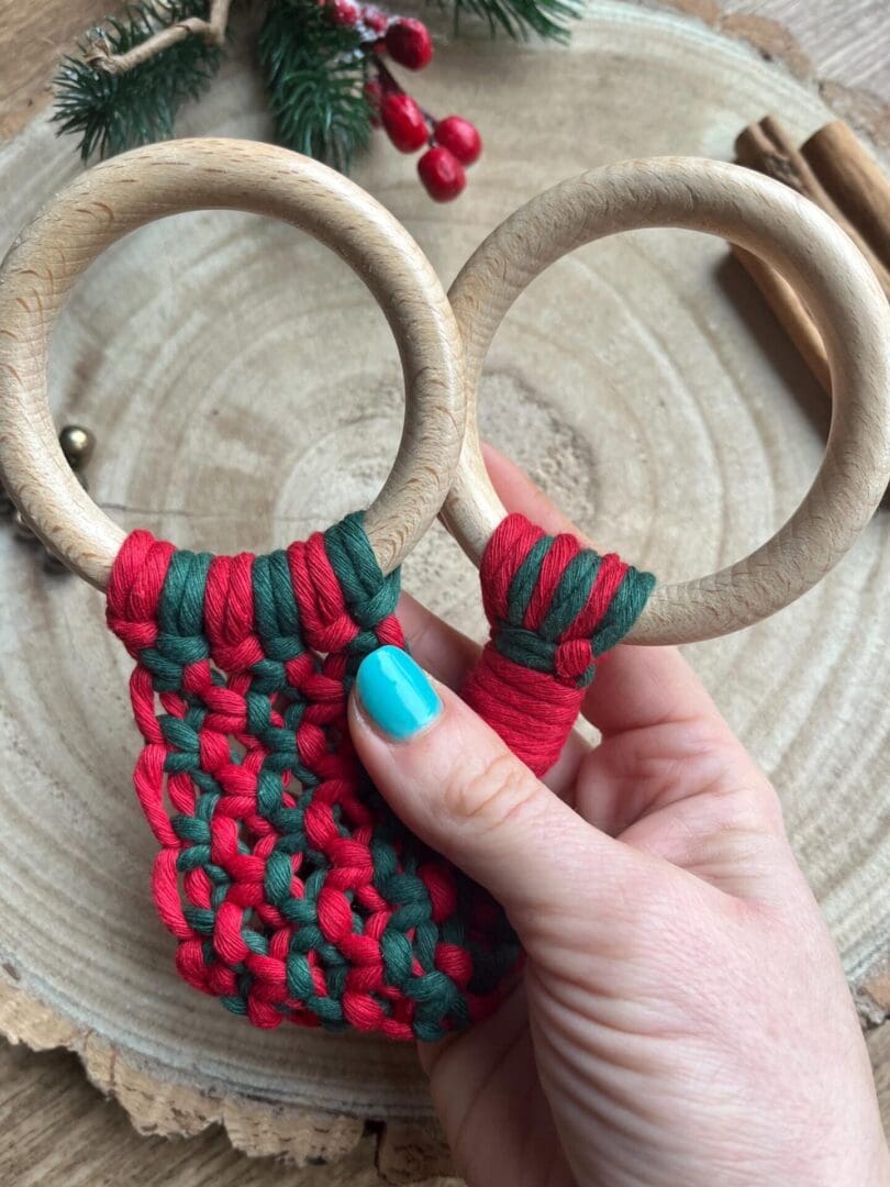 Handmade macrame tea towel holder, in festive Christmas colours of red and green, made with recycled cotton