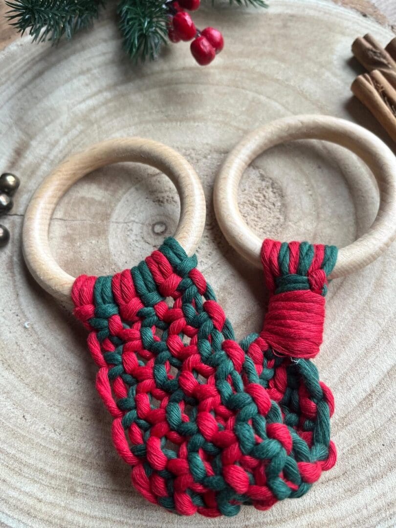 Handmade macrame tea towel holder, in festive Christmas colours of red and green, made with recycled cotton