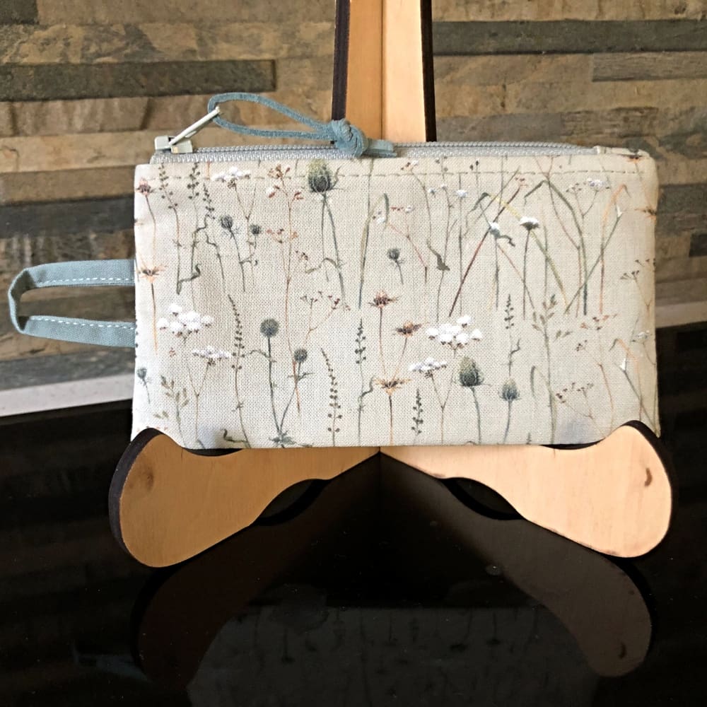 A coin and card purse, in grey blue with winter grasses and seedheads. . Integral handle to attaching to keys or a lanyard.