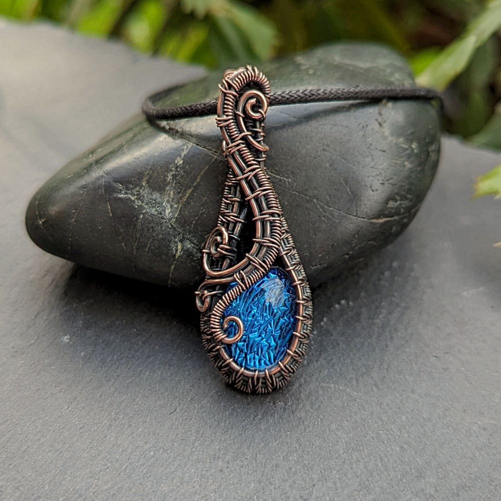 Copper wire wrapped pendant with blue dichroic glass nugget