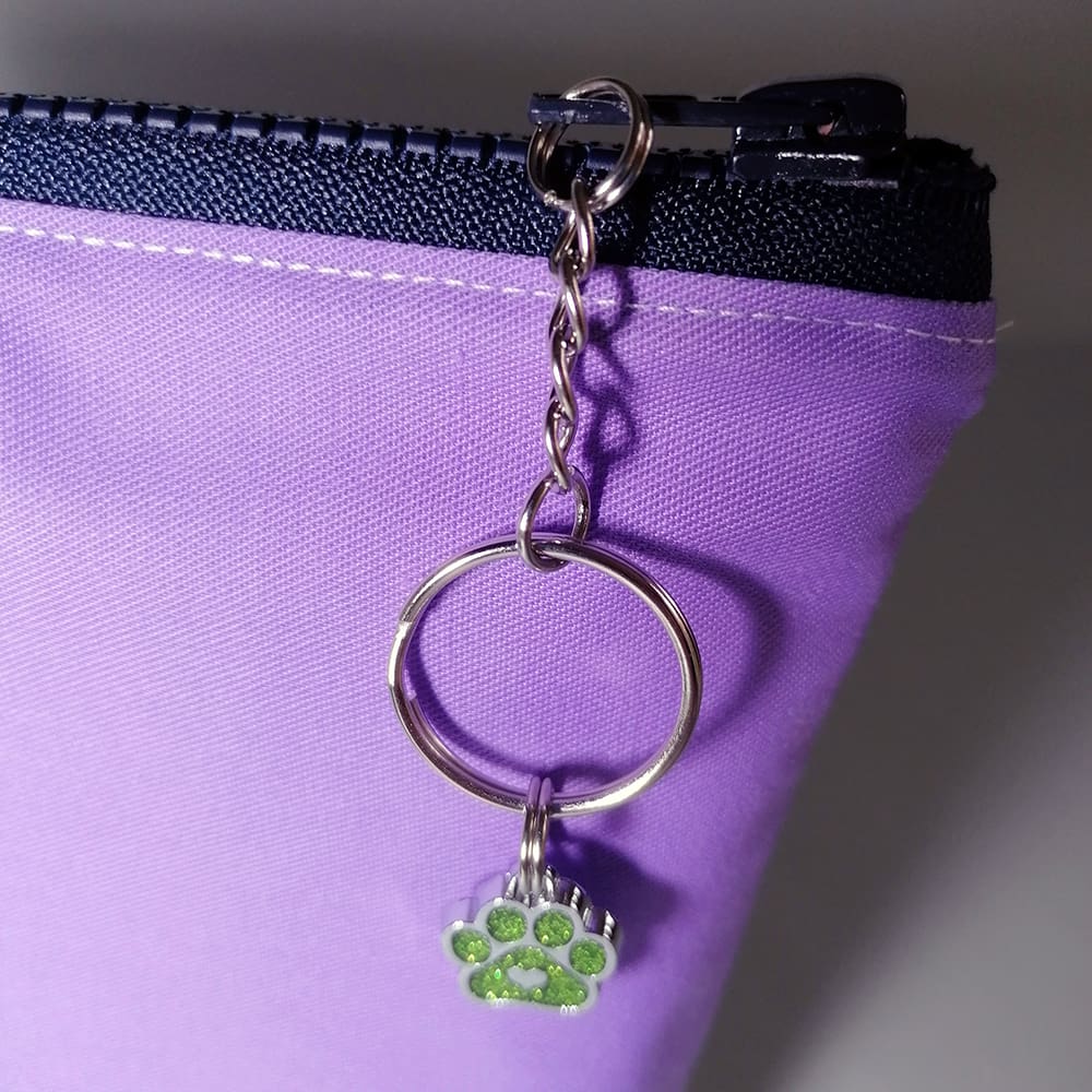 Sparkly paw print charm hangs from the chain zipper pull on the dog print make up bag