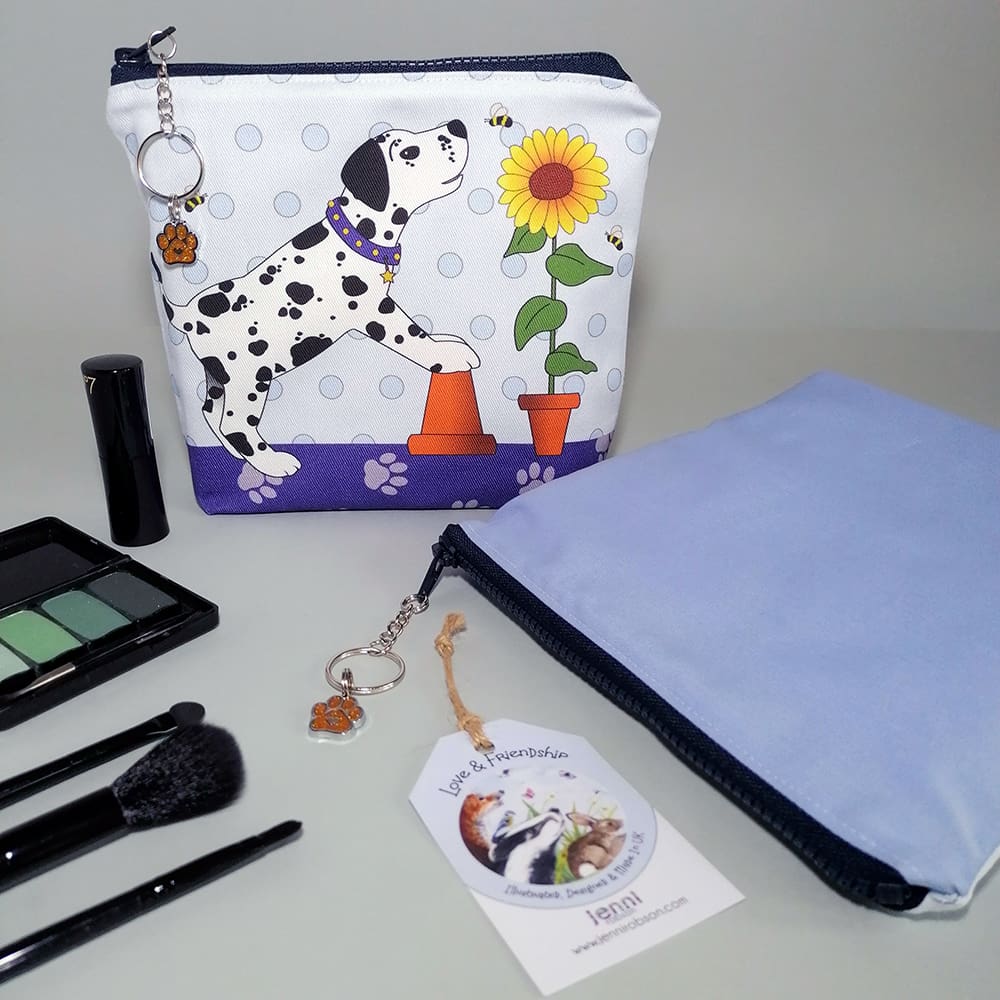 Spotty dog and sunflower print make up bag. Handmade in soft cotton with a water resistant lining and internal pocket. Sealed with a chunky zipper fastening with a ring and chain zip pull decorated with a dog paw charm.