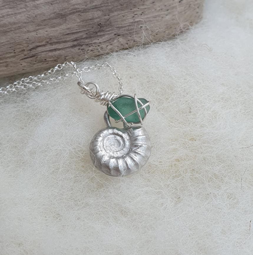 A silver ammonite and teal sea glass necklace