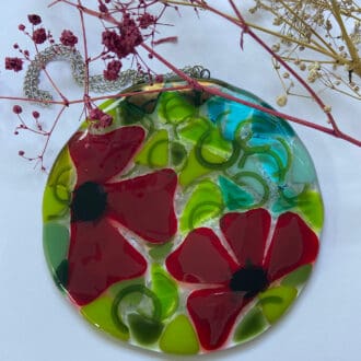 Fused glass sun catcher with poppy design.