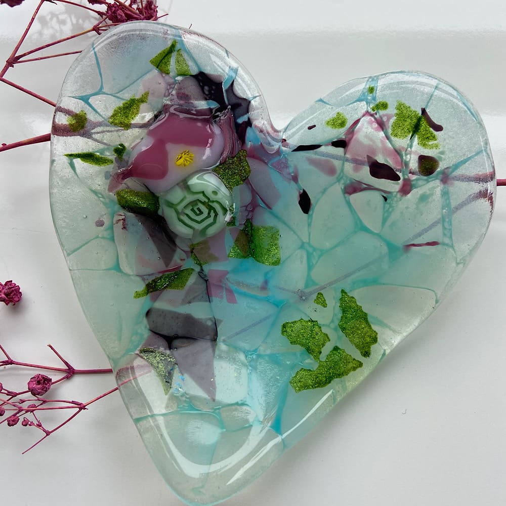 Heart shaped fused glass dish with flower elements.