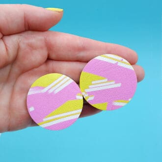 Graffiti inspired abstract art round stud earrings. Yellow and pink painted design