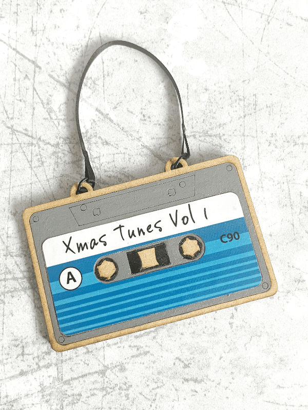 Cassette tape decoration with a grey tape and a blue label that says Xmas Tunes Vol 1