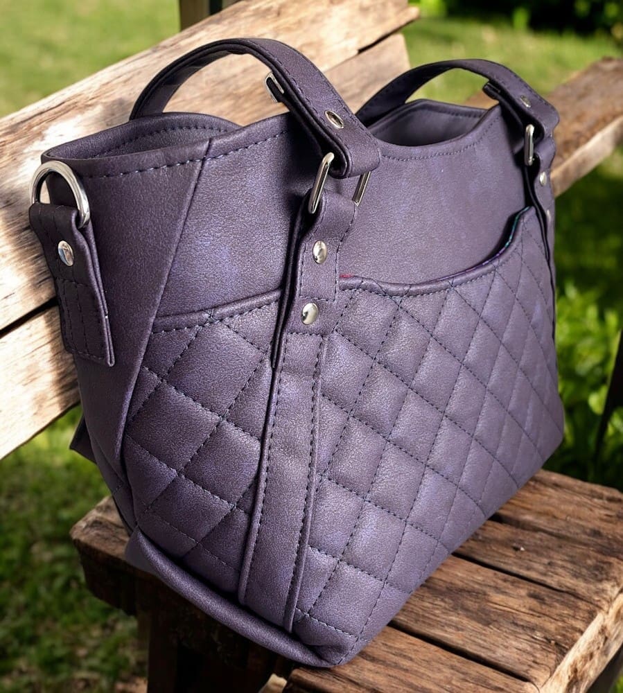 Vinyl handbag with quilted pockets, feature straps, origami-style seams and strap connectors