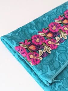 Handmade green foldover clutch bag with colourful floral trim