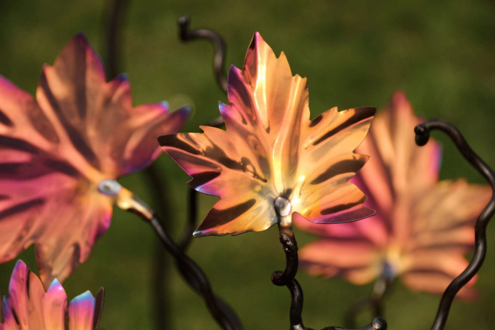 Detail of Maple leaf with vibrant autumn colours of golds, coppers, pink and purple, design craftmanship, stylish bird feeder tree stand. Handmade in the UK ,designed by Mark Reed