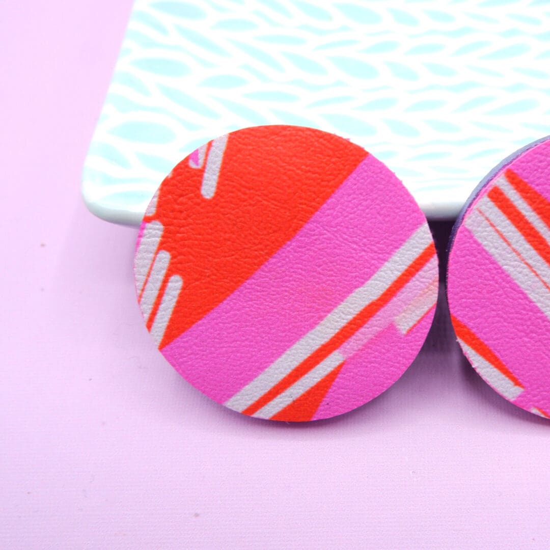 Close up of the red and pink colourway. Round abstract art stud earrings. Contemporary fashion style