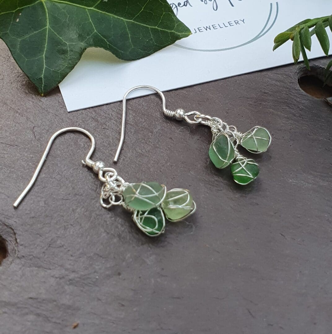 Silver and sea glass earrings in three shades of wire wrapped green sea glass