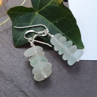 tiny white sea glass stacked together like pebbles hung as dangly earrings