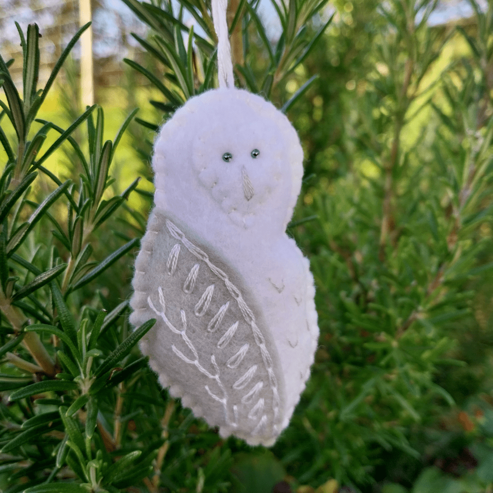 A hand stitched and embroidered felt snowy owl christmas decoration