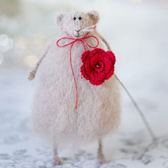 knitted mouse holding a red crochet rose