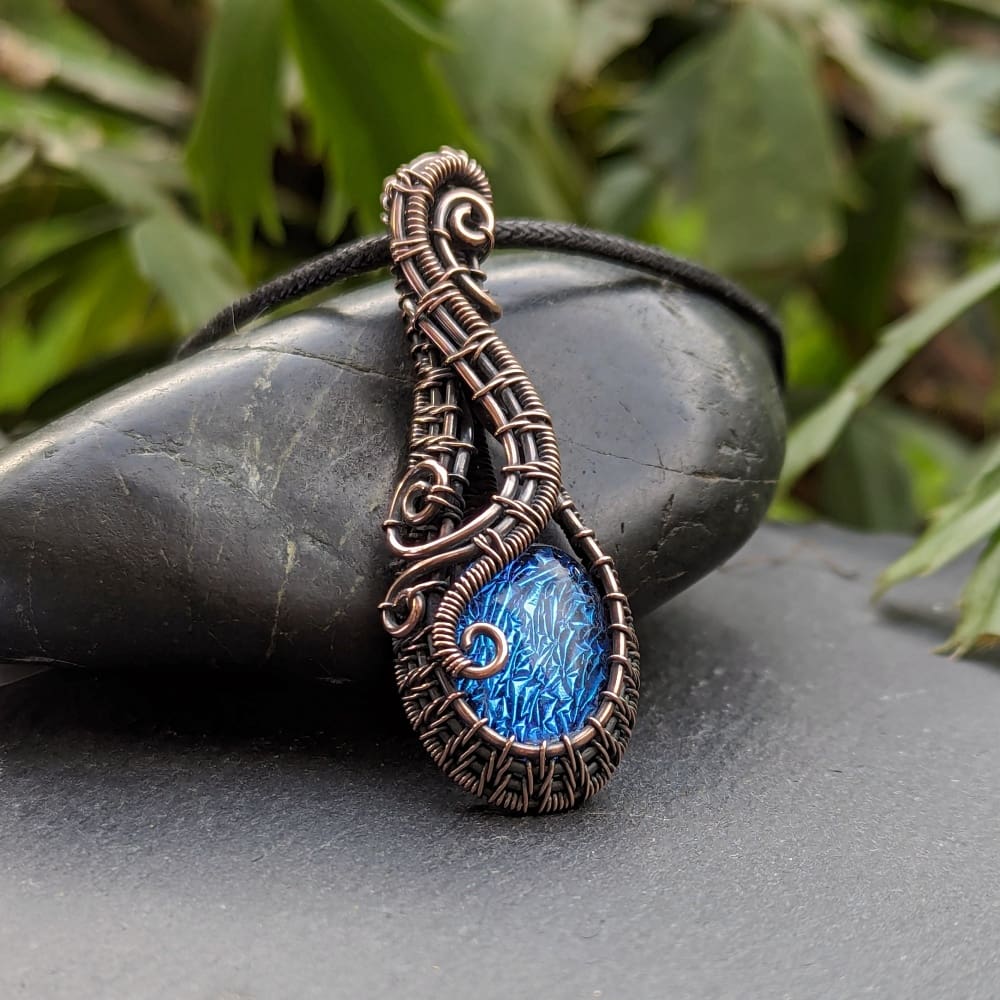 Wire woven copper pendant with blue dichroic glass