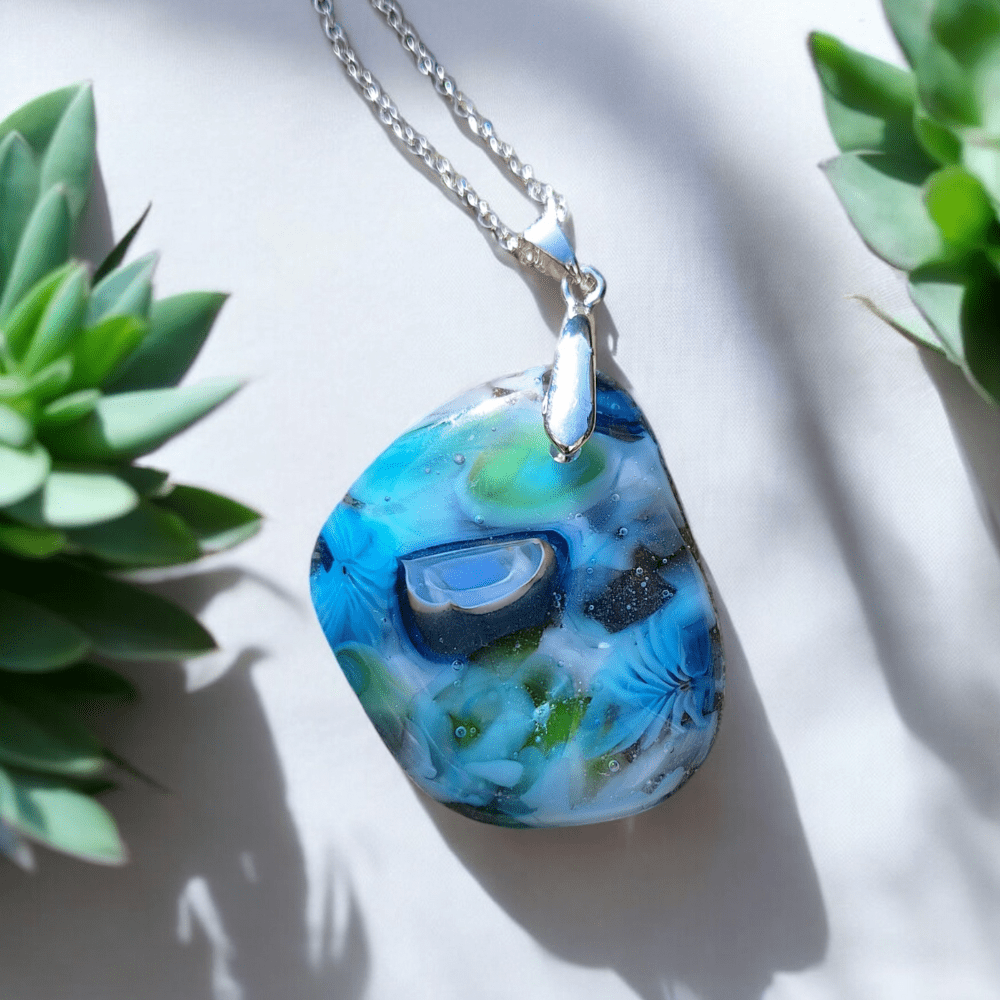 Handmade blue fused glass pendant with green accents on silver-plated chain – unique turquoise and blue-green boho necklace for Secret Santa, bridesmaids gifts, or best friend present. One-of-a-kind glass jewellery, crafted with intricate patterns and vibrant colours, perfect for a thoughtful Christmas or stocking filler gift.