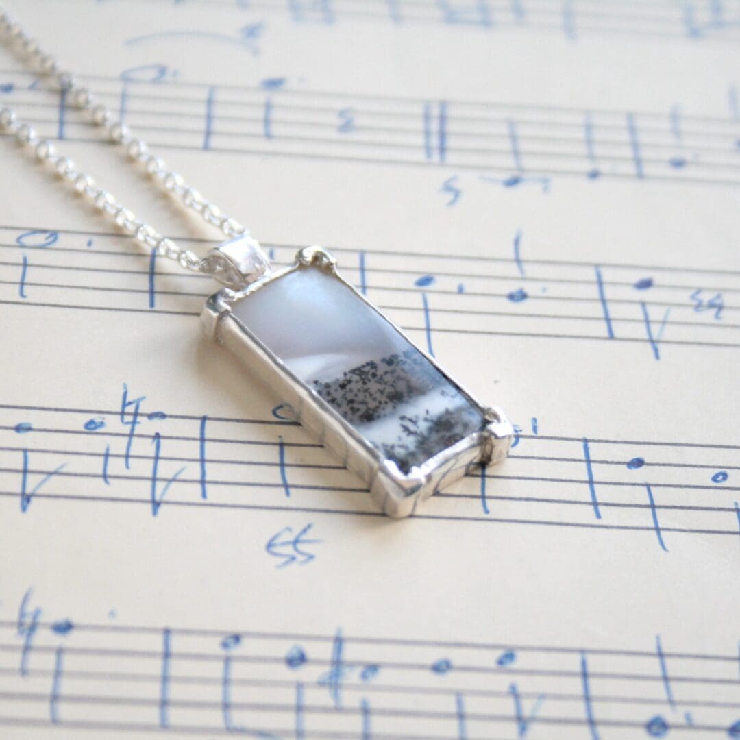 Rectangular dendritic opal gemstone necklace with a tree cut-out on the back