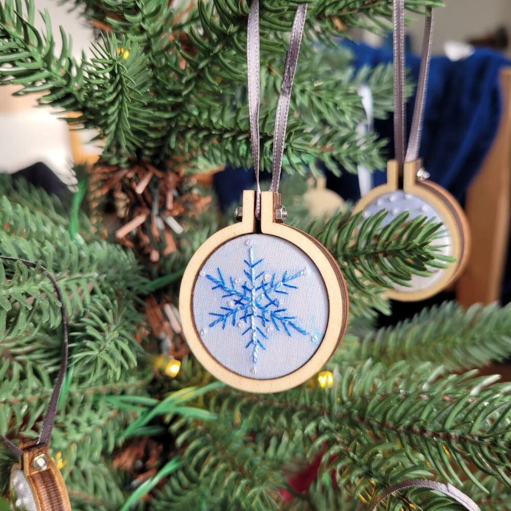 Hand embroidered snowflake christmas tree decoration set in a 4cm mini embroidery hoop.