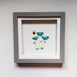 framed picture of three forget me not flowers made from Cornish sea glass