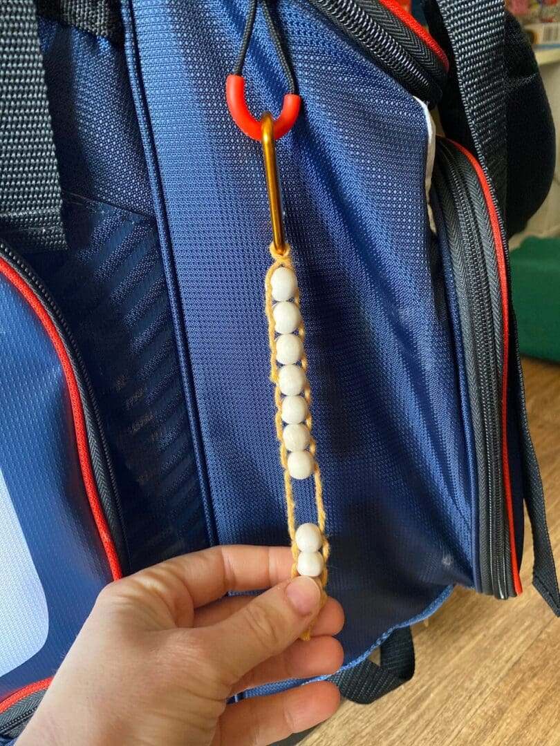 Golf Stroke counter made with recycled cotton, and wooden beads on a carabiner clip