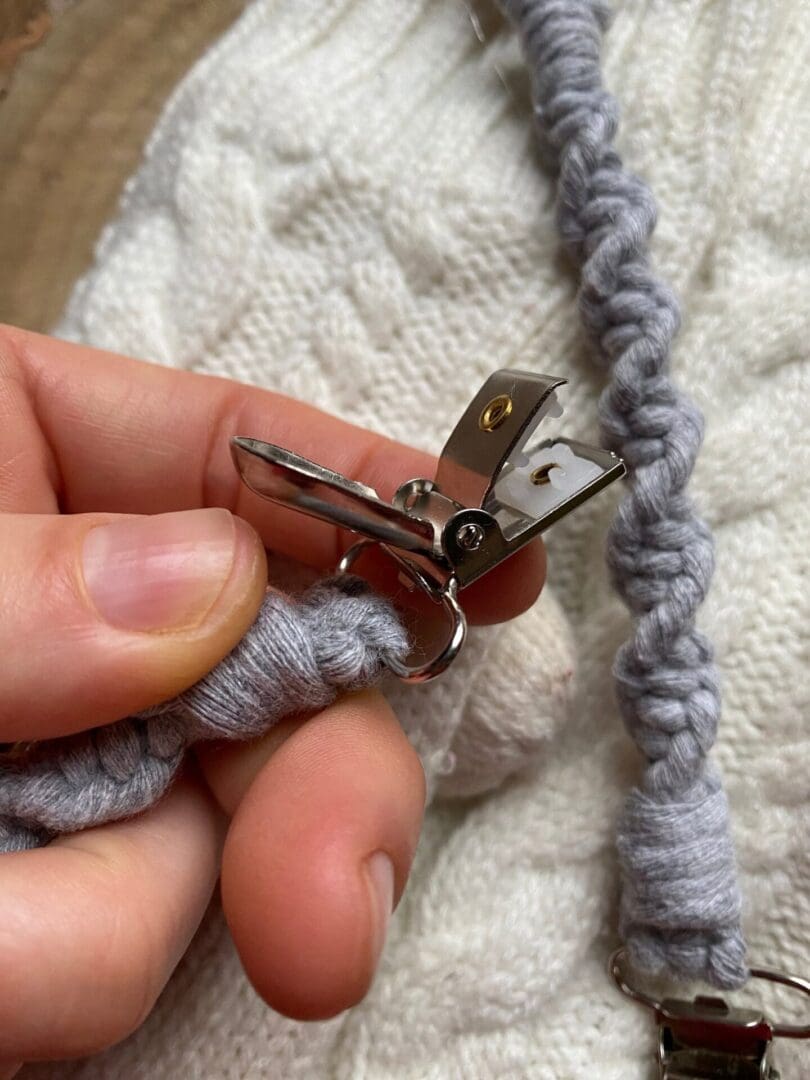 A pair of grey mitten clips made with recycled cotton