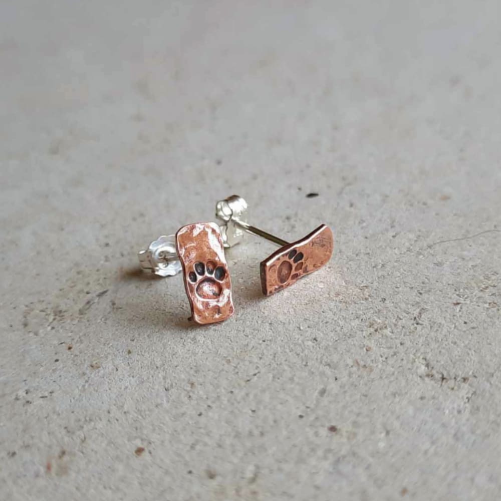 Hand stamped copper paw print stud earrings, artisan made by The Tiny Tree Frog Jewellery